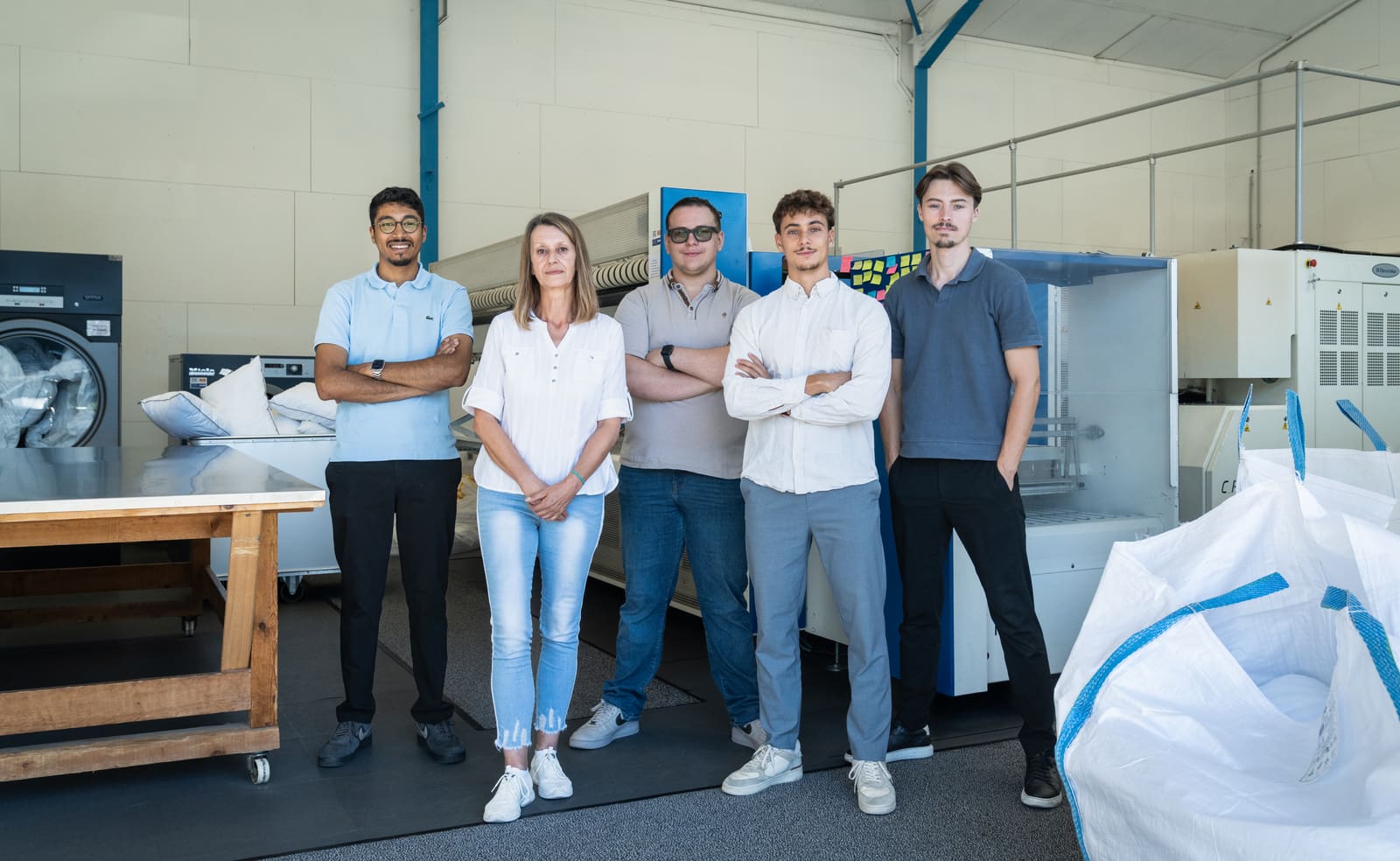 L'équipe de L'Étoffe Blanche dans l'atelier de Sallanches, devant les machines de blanchisserie