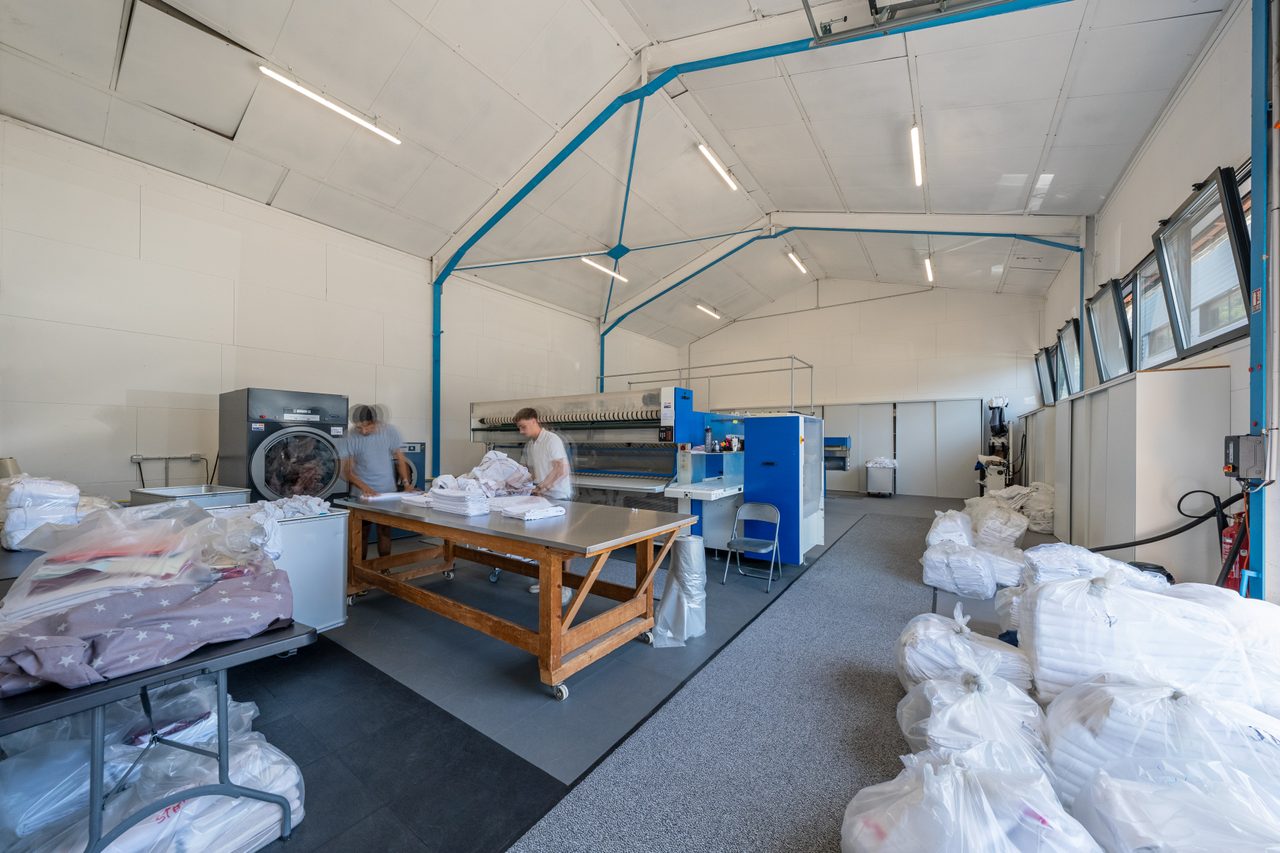 L'atelier de la blanchisserie : pliage du linge de maison et calandreuse