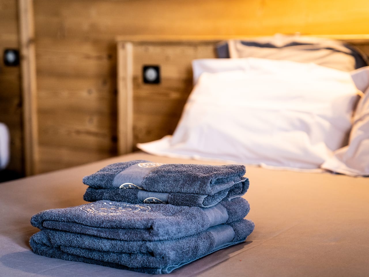 Serviettes de bain moelleuses pliées sur un lit d'hôtel