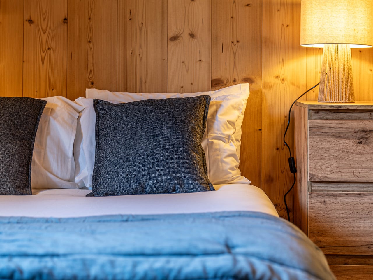 Lit dressé de linge frais dans une chambre de chalet